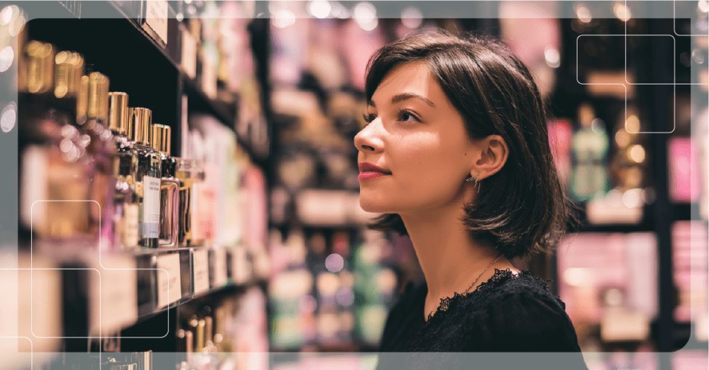 Consumidora observando frascos de cosmética y perfumería en el lineal de una tienda de belleza